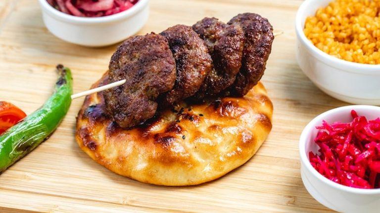צ'בפי בוסנית מוגשת בפיתת סומון עם בצל טרי
