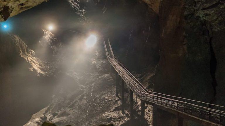 אולם תצורות אבן וטורי זליגה מוארים בעומק מערת ויטרניצה בהרצגובינה